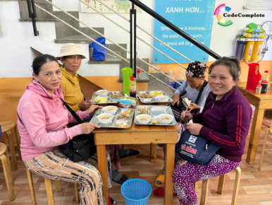 Elderly guests smiling as they receive nutritious lunch trays at Yen Vui Kitchen Da Nang — a simple act of kindness with lasting impact.