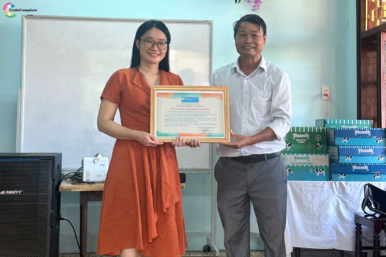 CodeComplete representative receiving a certificate of appreciation from SOS Village Da Nang, recognizing community care efforts.