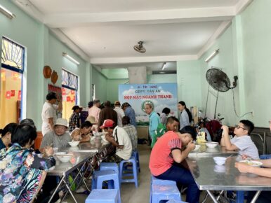 A large group of local Da Nang community members gathered inside a dining hall at Tan An Pagoda,